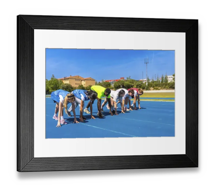 Framed Print : Diverse group of athletes ready to start a race on a blue running track