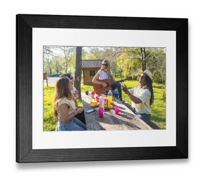 Framed Print : Happy friends are having a picnic in a park