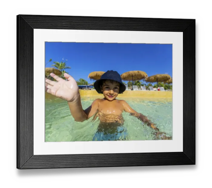 Framed Print : Smiling child in a sun hat waves while playing in a clear swimming pool Framed Print : Smiling child in a sun hat waves while playing in a clear swimming pool