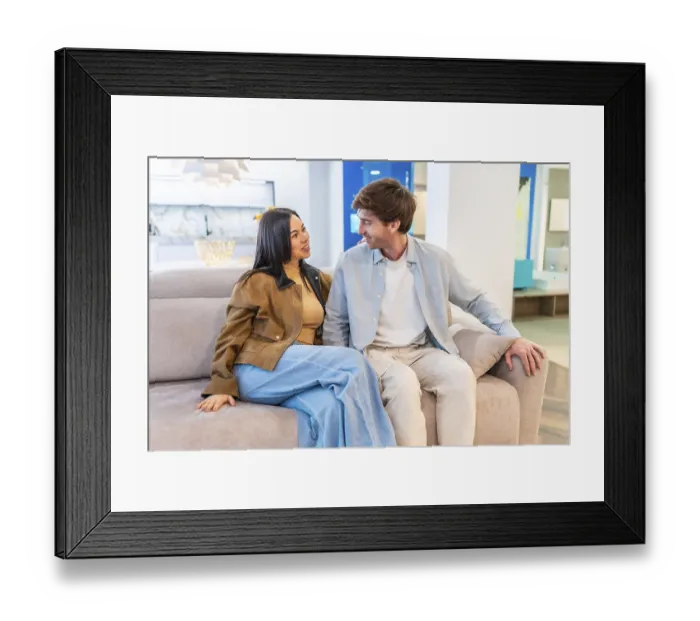 Framed Print : Happy couple enjoying the comfort of a new couch Framed Print : Happy couple enjoying the comfort of a new couch