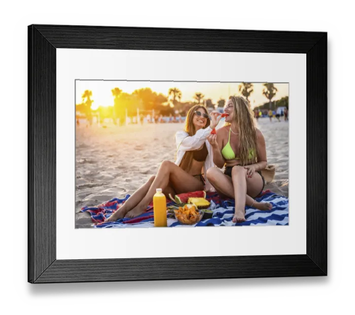 Framed Print : Two female friends enjoying watermelon and other snacks on a beach towel at sunset Framed Print : Two female friends enjoying watermelon and other snacks on a beach towel at sunset