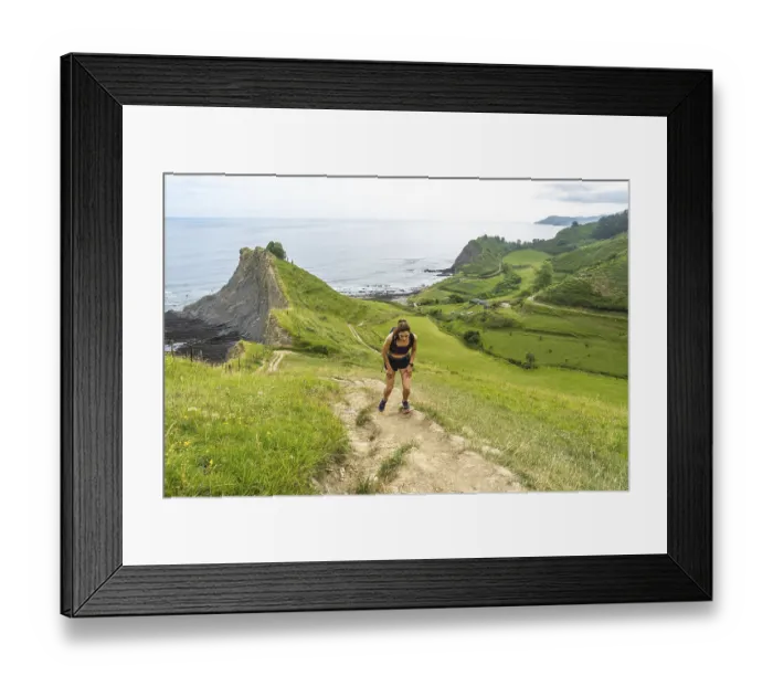 Framed Print : Tired athlete taking a break during trail running workout along the picturesque cliffs of zumaia