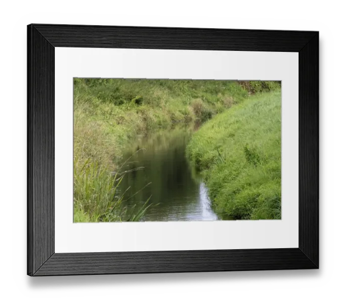 Framed Print : Clean river flowing through lush green grass and vegetation in a peaceful natural landscape Framed Print : Clean river flowing through lush green grass and vegetation in a peaceful natural landscape