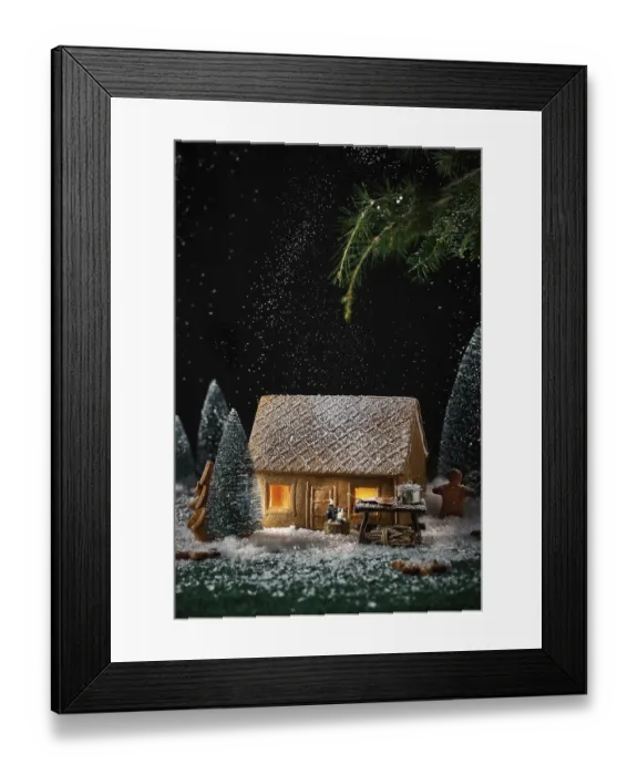 Framed Print : Decorating a little house made of cookies with Christmas decorations
