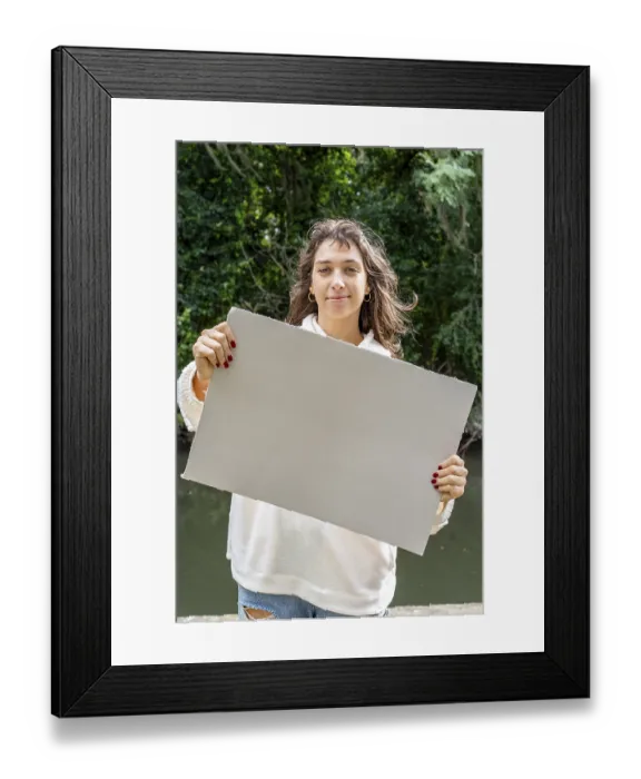 Framed Print : Vertical shot of a Woman holding a blank sign by the river
