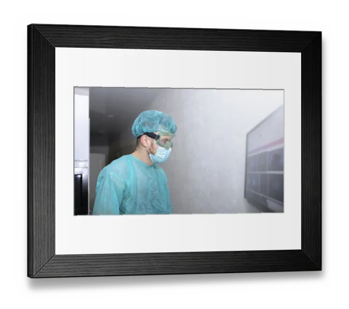 Framed Print : A medical professional in protective gear stands by a wall