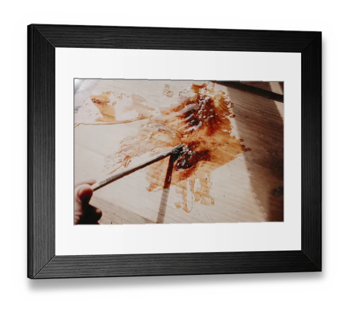 Framed Print : Sunlight casts shadows on painted wood as a brush moves delicately