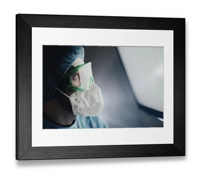 Framed Print : A medical professional in protective gear looking at a bright screen Framed Print : A medical professional in protective gear looking at a bright screen