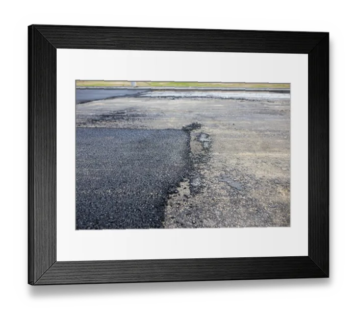 Framed Print : Road with contrasting areas of new asphalt and old surface in a wide view