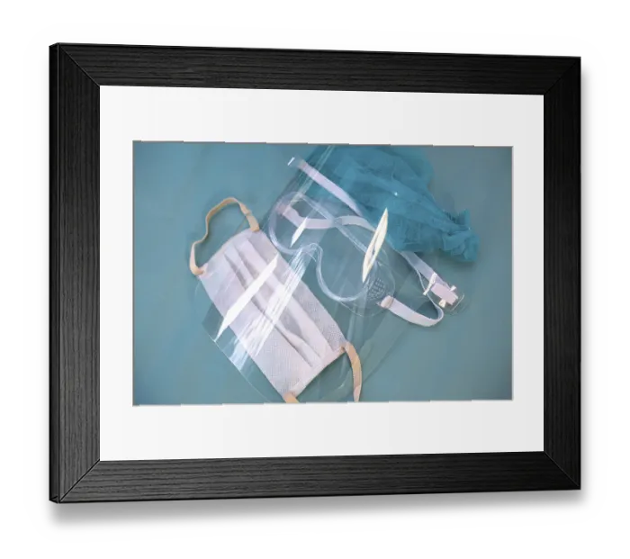 Framed Print : A protective set including a mask and glasses with a clear shield on a teal surface