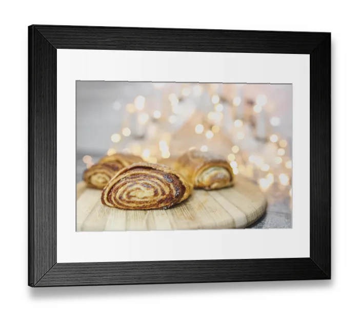 Framed Print : Rolled pastries on a wooden board against a bokeh light backdrop Framed Print : Rolled pastries on a wooden board against a bokeh light backdrop