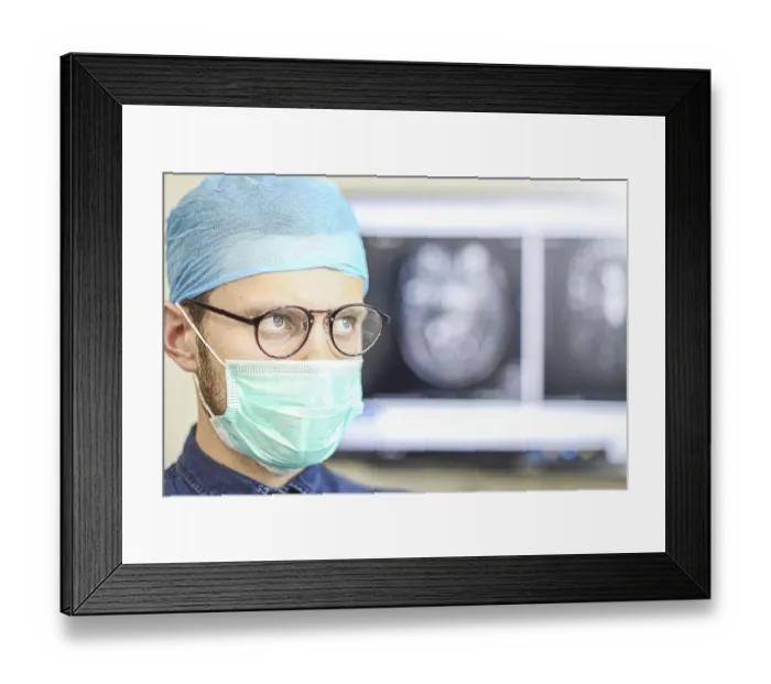 Framed Print : A focused surgeon wearing glasses and a mask