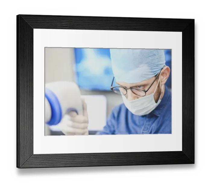 Framed Print : Doctor in medical attire focused on equipment