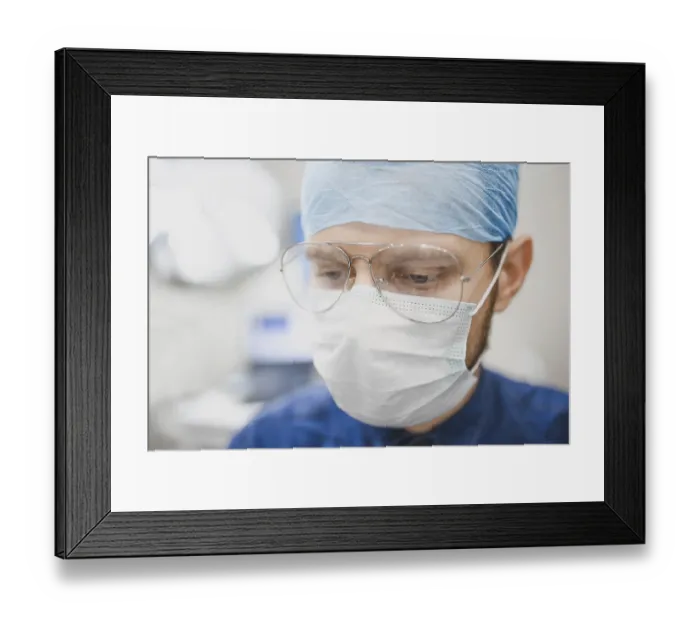 Framed Print : Doctor with glasses and a surgical mask focused on work