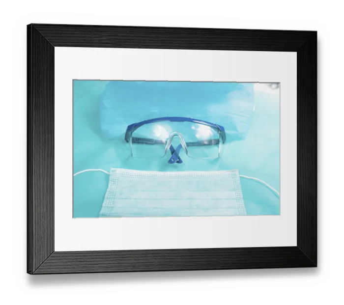 Framed Print : Protective glasses and a surgical mask placed on a blue surface
