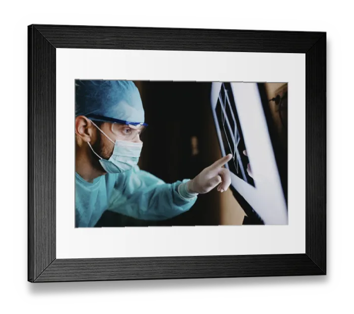 Framed Print : A medical staff member focusing on a screen displaying data in a protected setting