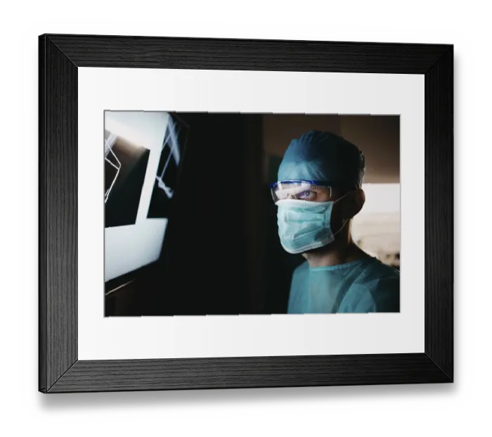 Framed Print : Healthcare worker in scrubs analyzing x-ray images attentively