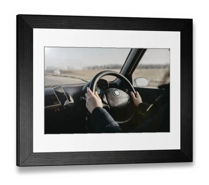 Framed Print : Hands on a steering wheel with sunlight illuminating the interior during a drive Framed Print : Hands on a steering wheel with sunlight illuminating the interior during a drive