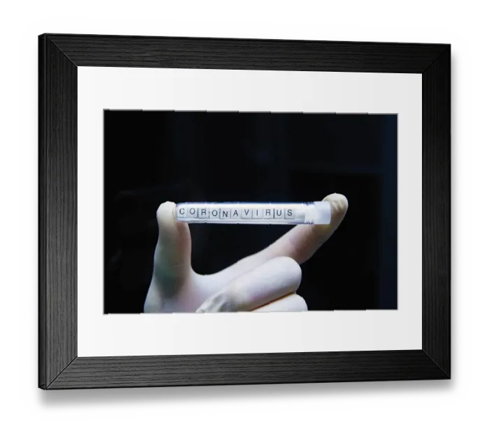 Framed Print : A gloved hand displays a test tube labeled coronavirus against a black background