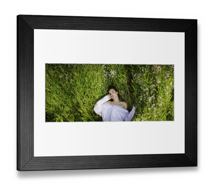 Framed Print : A woman lies in a field of green plants