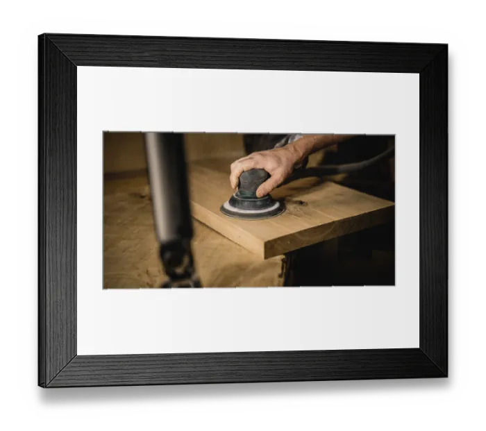 Framed Print : Hand sanding a wooden plank in a workshop