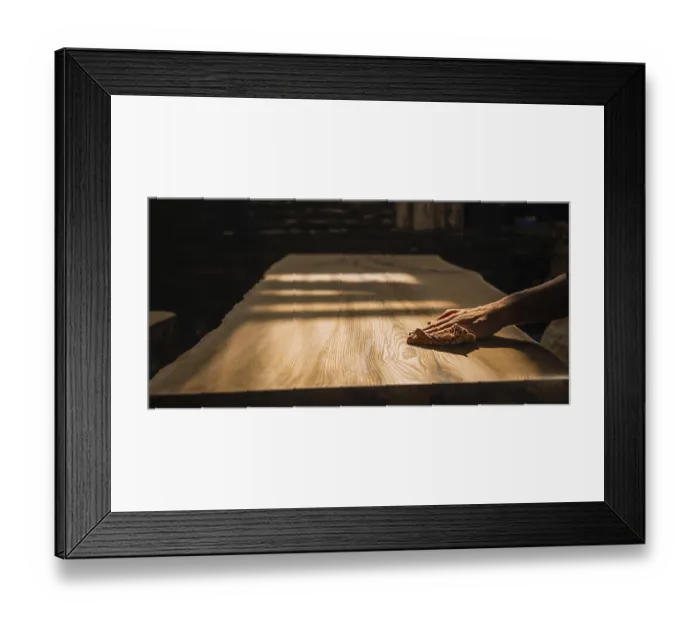 Framed Print : A hand gently sanding a wooden surface under warm lighting