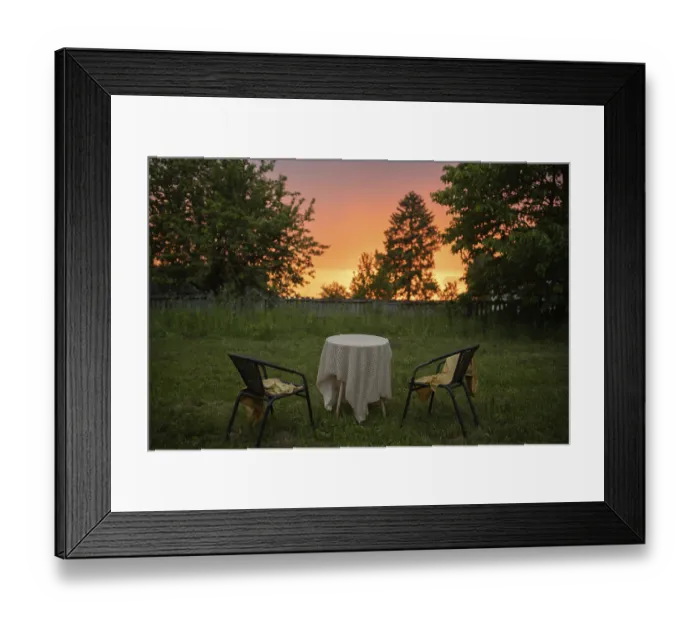 Framed Print : Garden scene with two chairs and a table under a sunset sky Framed Print : Garden scene with two chairs and a table under a sunset sky