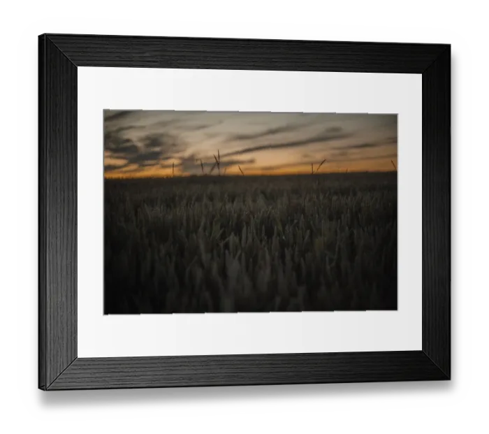 Framed Print : A serene field at twilight with dark tones and distinctive cloud formations