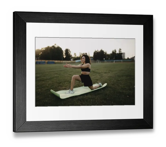 Framed Print : A woman stretches on a yoga mat in a park