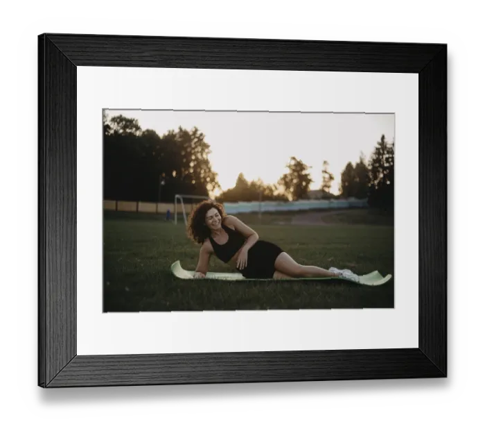 Framed Print : A woman relaxes on a yoga mat at sunset