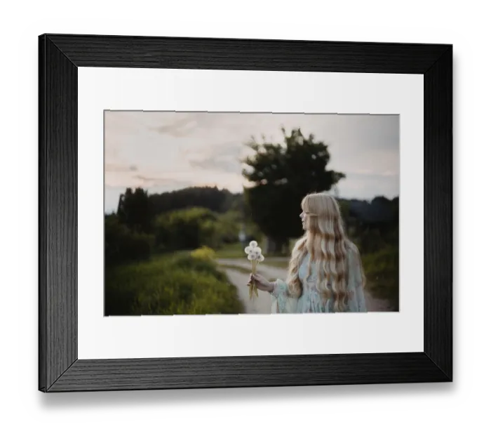 Framed Print : A woman holding a bouquet of dandelions on a countryside path