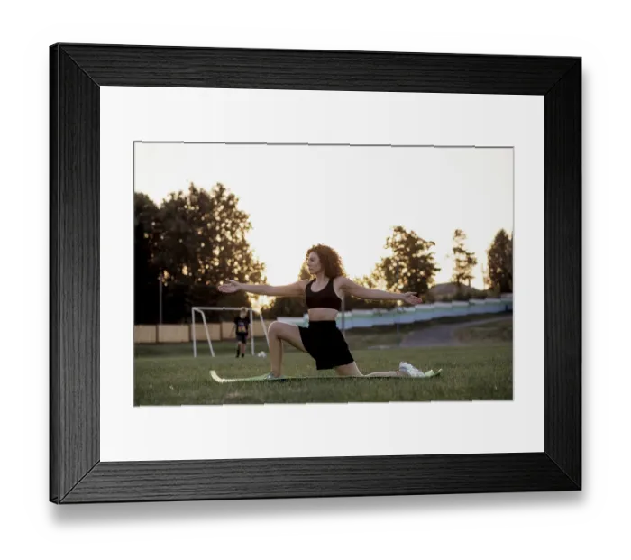 Framed Print : Woman extending arms while performing a yoga pose in a park during sunset Framed Print : Woman extending arms while performing a yoga pose in a park during sunset