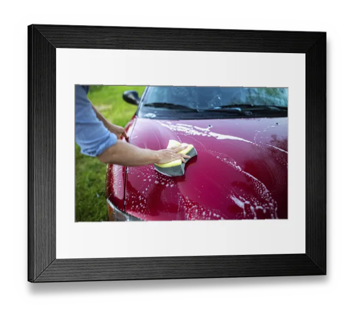 Framed Print : Hand using a sponge to wash the hood of a red car with soap and suds