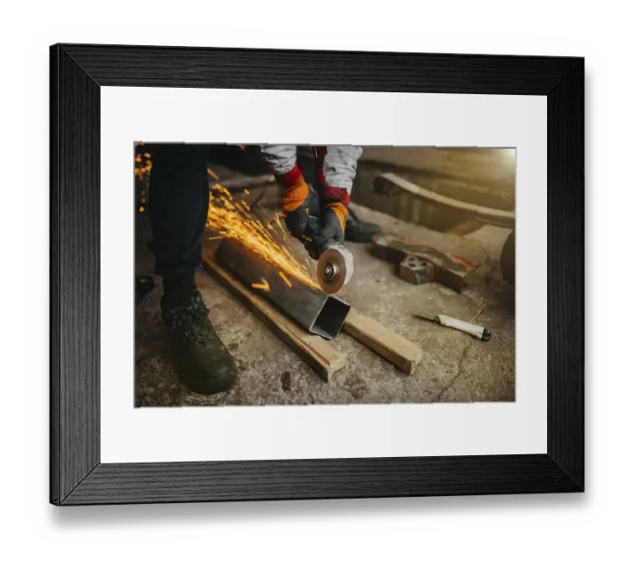 Framed Print : A worker grinding metal with sparks flying