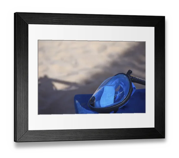 Framed Print : Blue diving mask resting on a surface with sandy beach in the background Framed Print : Blue diving mask resting on a surface with sandy beach in the background