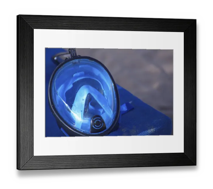 Framed Print : Close-up of a blue diving mask on a blue surface by the beach