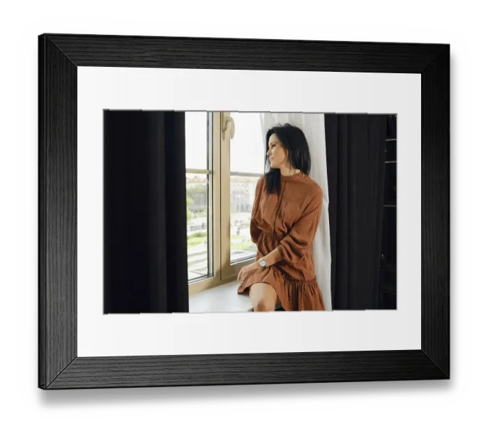 Framed Print : A woman in a brown dress relaxes by a large window