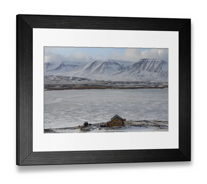 Framed Print : An isolated holiday home in a snow-covered landscape against an impressive mountain backdrop