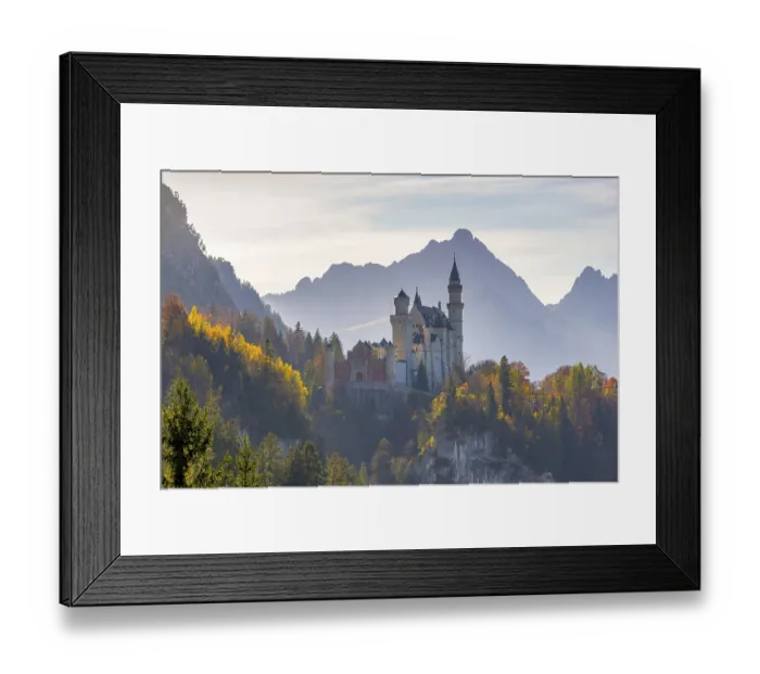 Framed Print : Fairytale Neuschwanstein Castle surrounded by autumnal trees against a mountain backdrop
