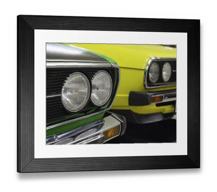 Framed Print : Front view of two classic cars in bright colours with striking headlights