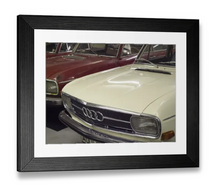 Framed Print : Front view of a white Audi classic car in a garage with a red car next to it Framed Print : Front view of a white Audi classic car in a garage with a red car next to it