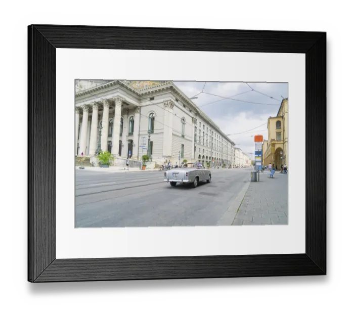 Framed Print : A classic car drives alongside a magnificent building in Munich