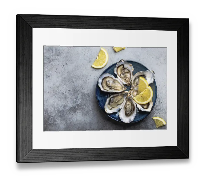 Framed Print : Set of half dozen fresh opened oysters in shell with lemon wedges served on rustic blue plate on gray stone background