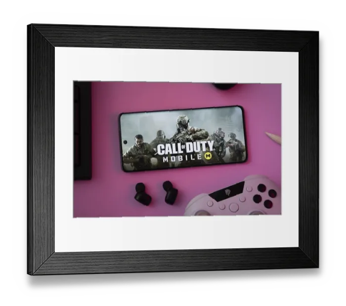 Framed Print : Dhaka, Bangladesh- 06 Sep 2025: A close-up of a gamepad with the Call of Duty Mobile seen on smartphone
