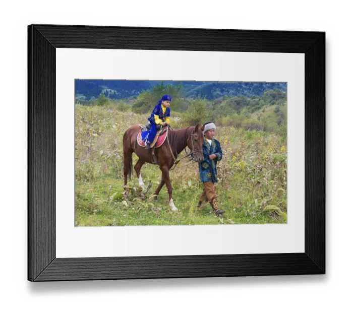 Framed Print : Kazakh man walking around on a horse with his son after the circumcision Sundet Toi ceremony