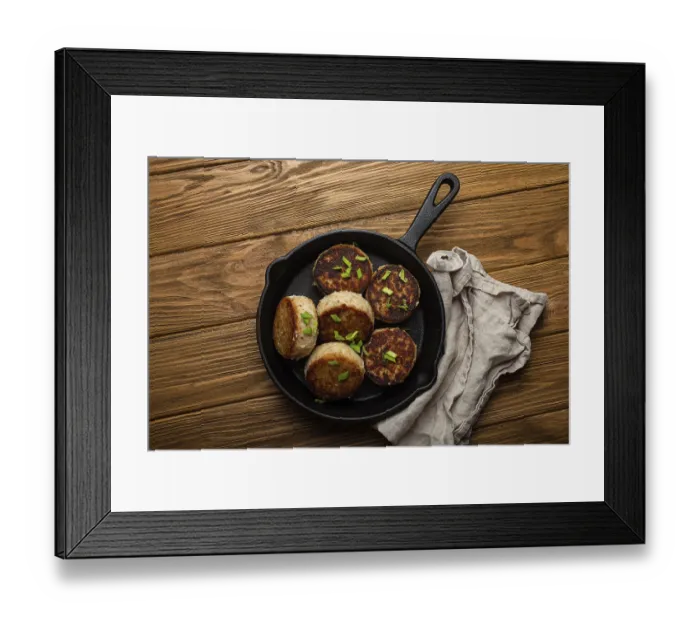 Framed Print : Homemade cutlets from fish, chicken or meat on black cast iron frying pan skillet on rustic wooden table