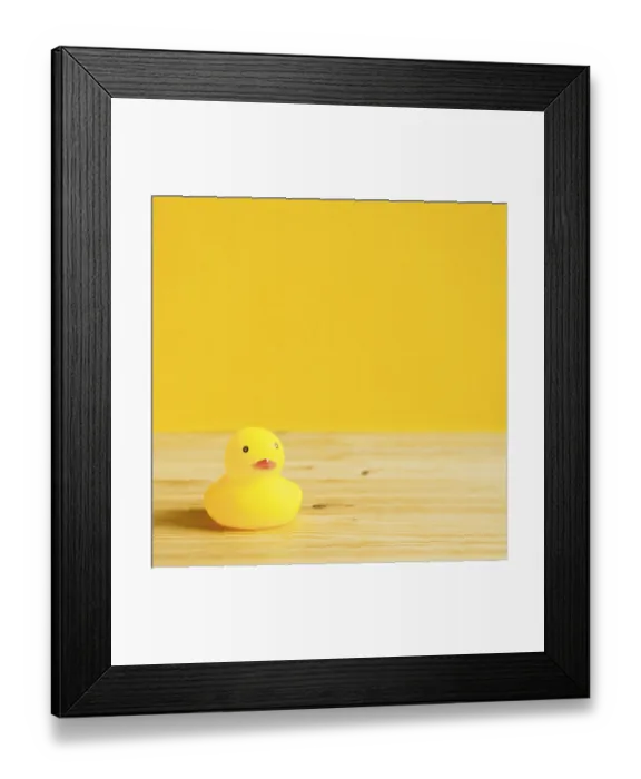 Framed Print : Yellow rubber duck doll on wooden table