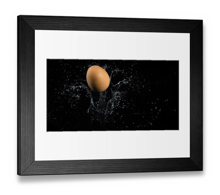 Framed Print : Egg Falling on Water against Black Background
