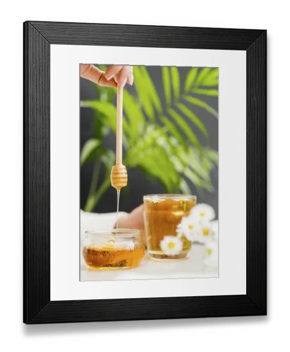 Framed Print : Woman holding glass with tea honey dipper