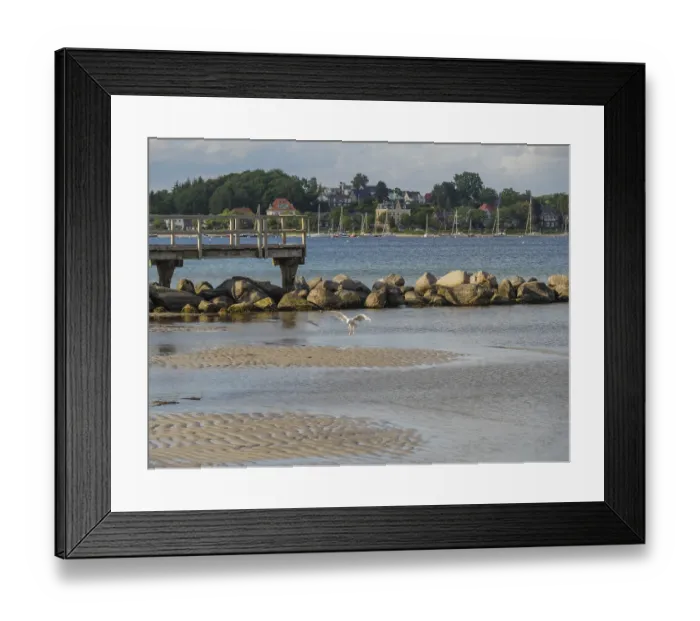 Framed Print : A jetty leads into the water, seagulls fly over the calm lake